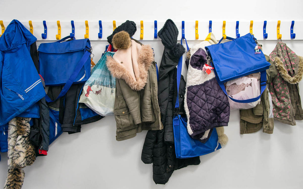 school-environment coat hangers filled with children's bags and coats