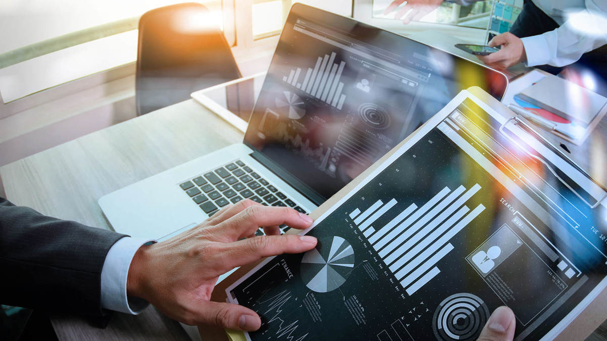 tools-resources someone checking over graphs on their laptop and tablet