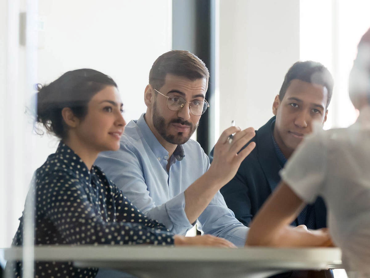 man discussing something with colleagues in a meeting