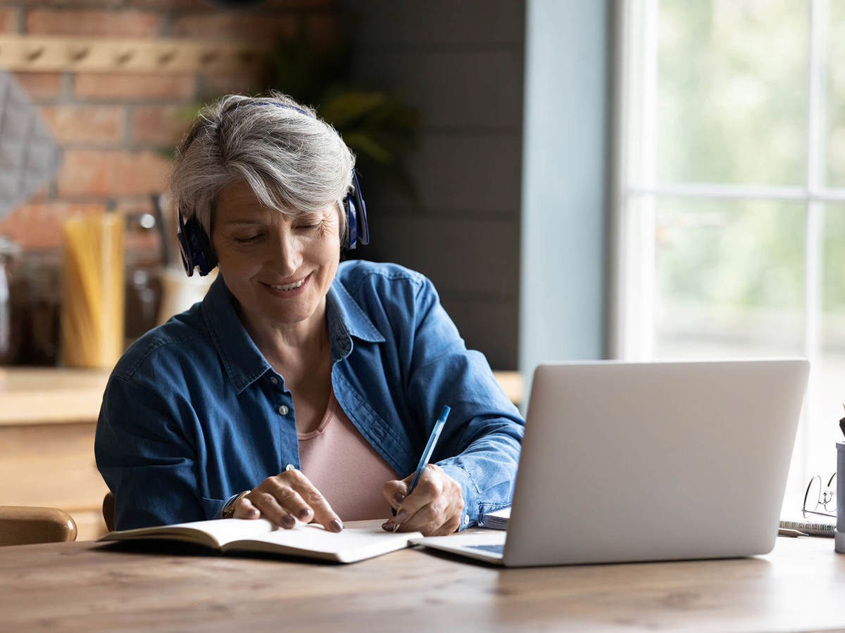 people woman writing notes off her laptop