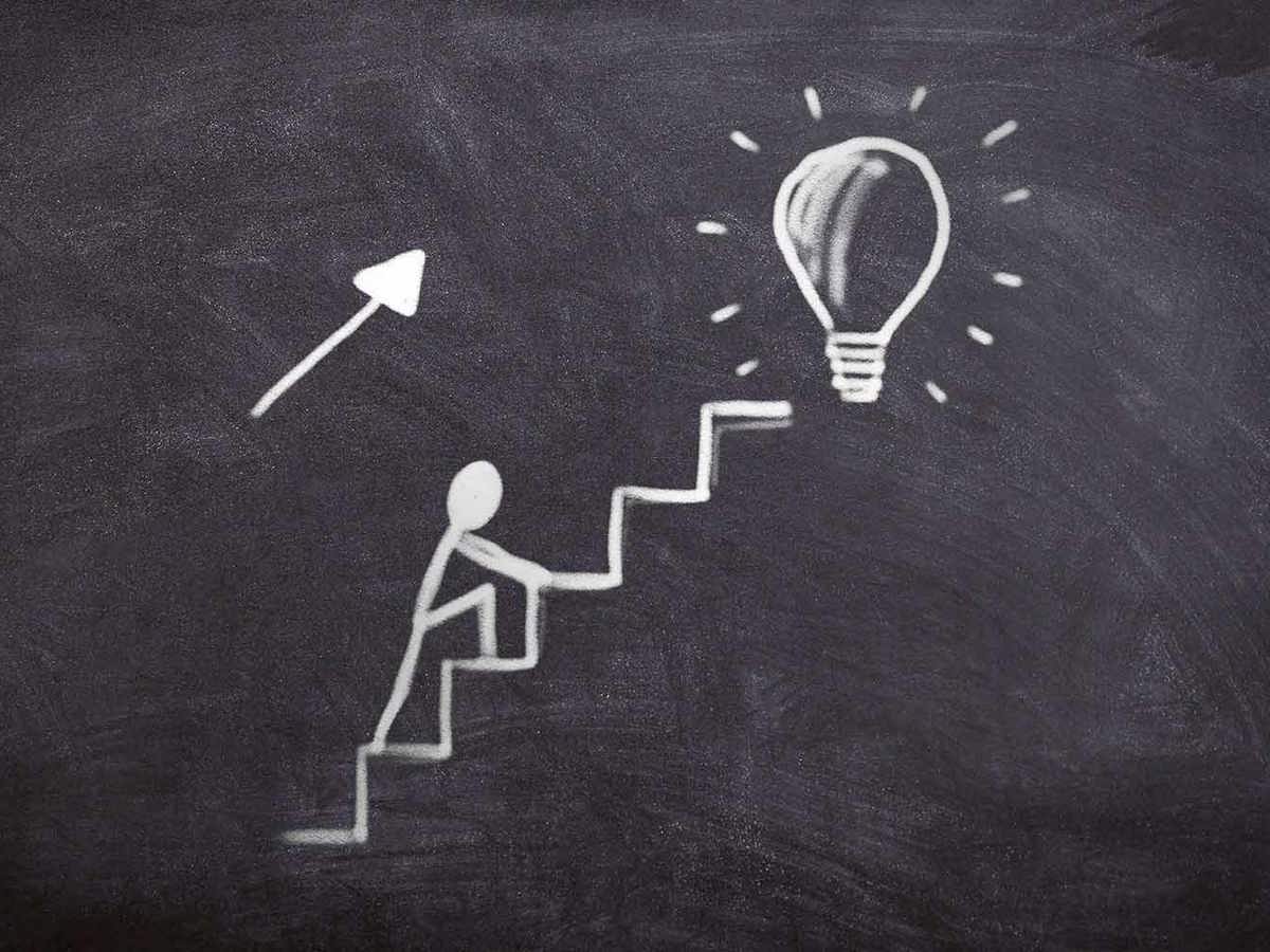 vision of someone climbing stairs to reach the light bulb