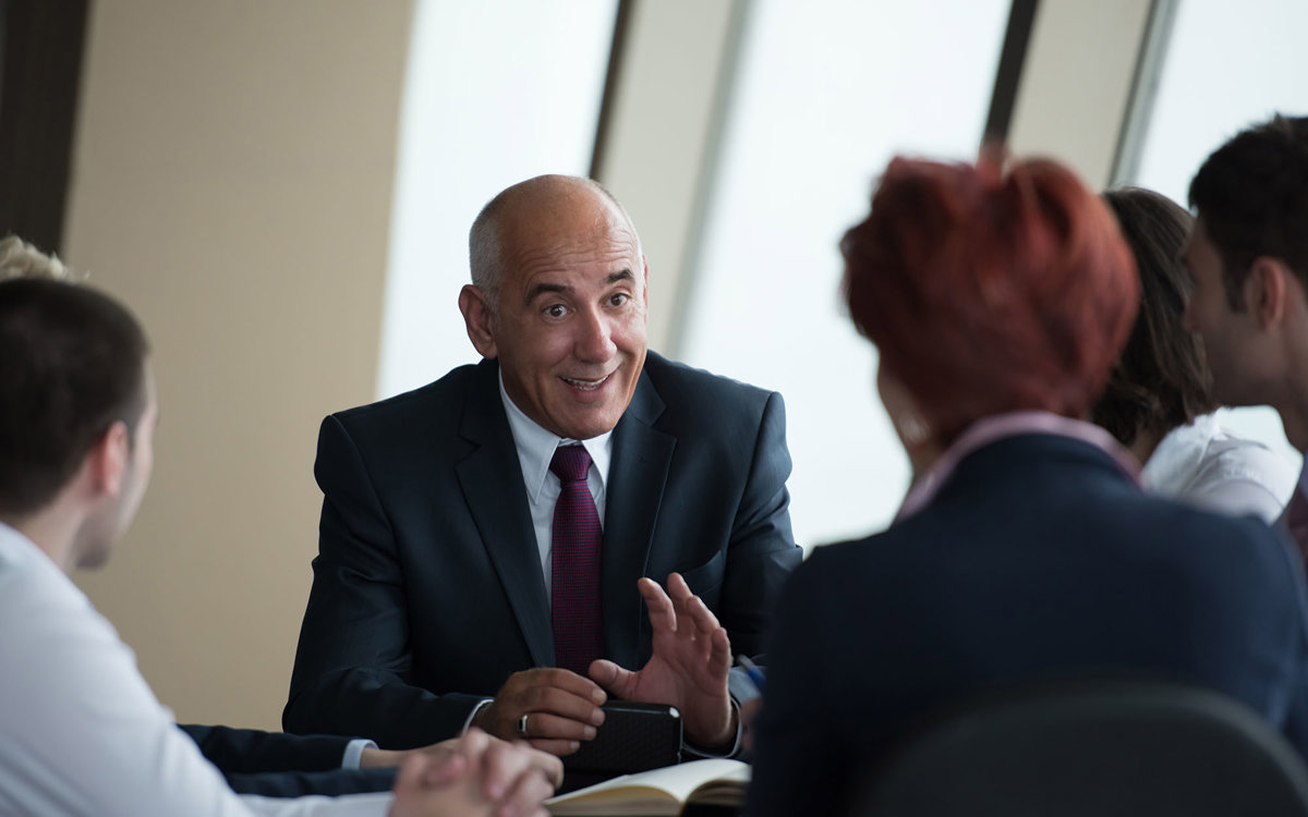 training senior man discussing to a blurred group