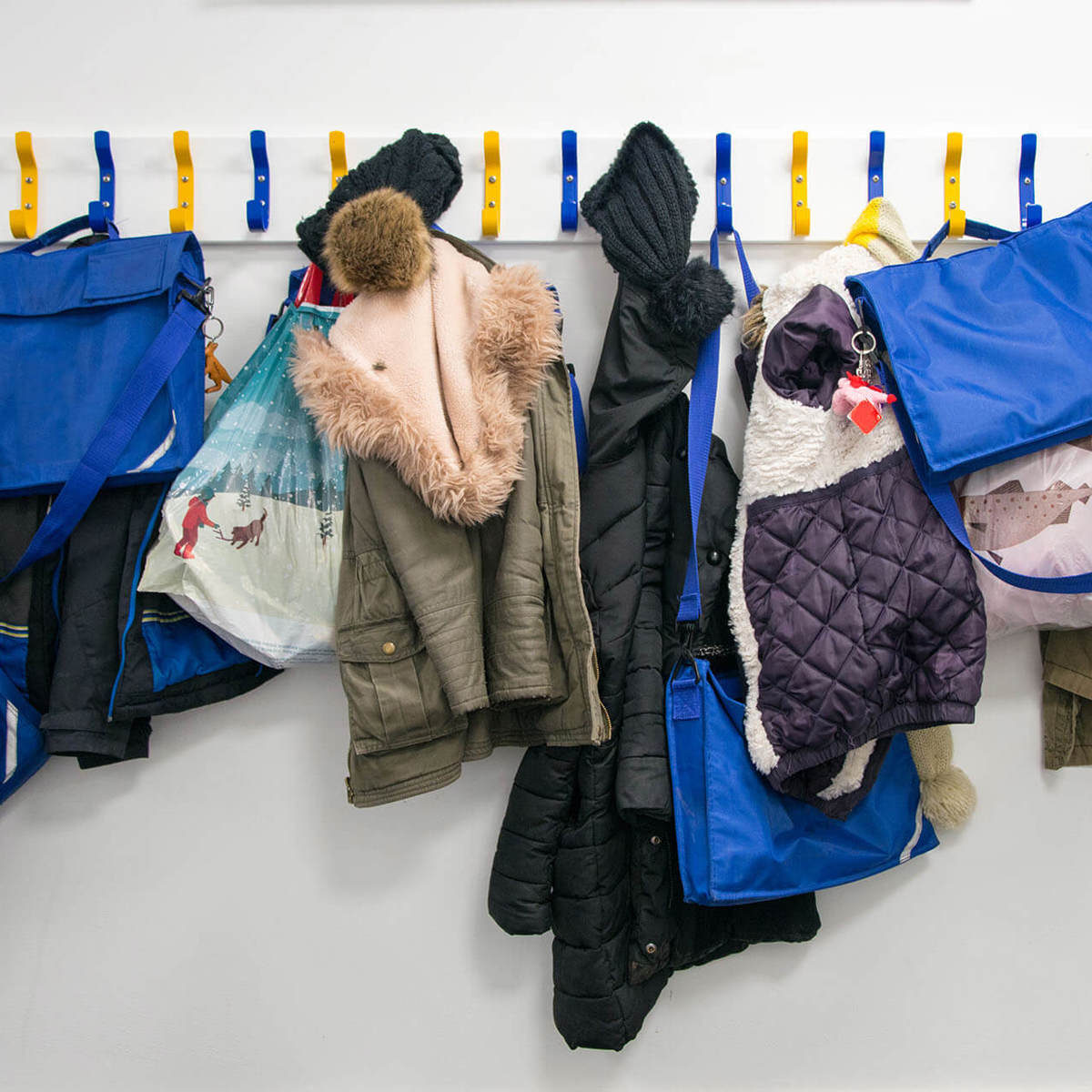 school-environment coat hangers filled with children's bags and coats