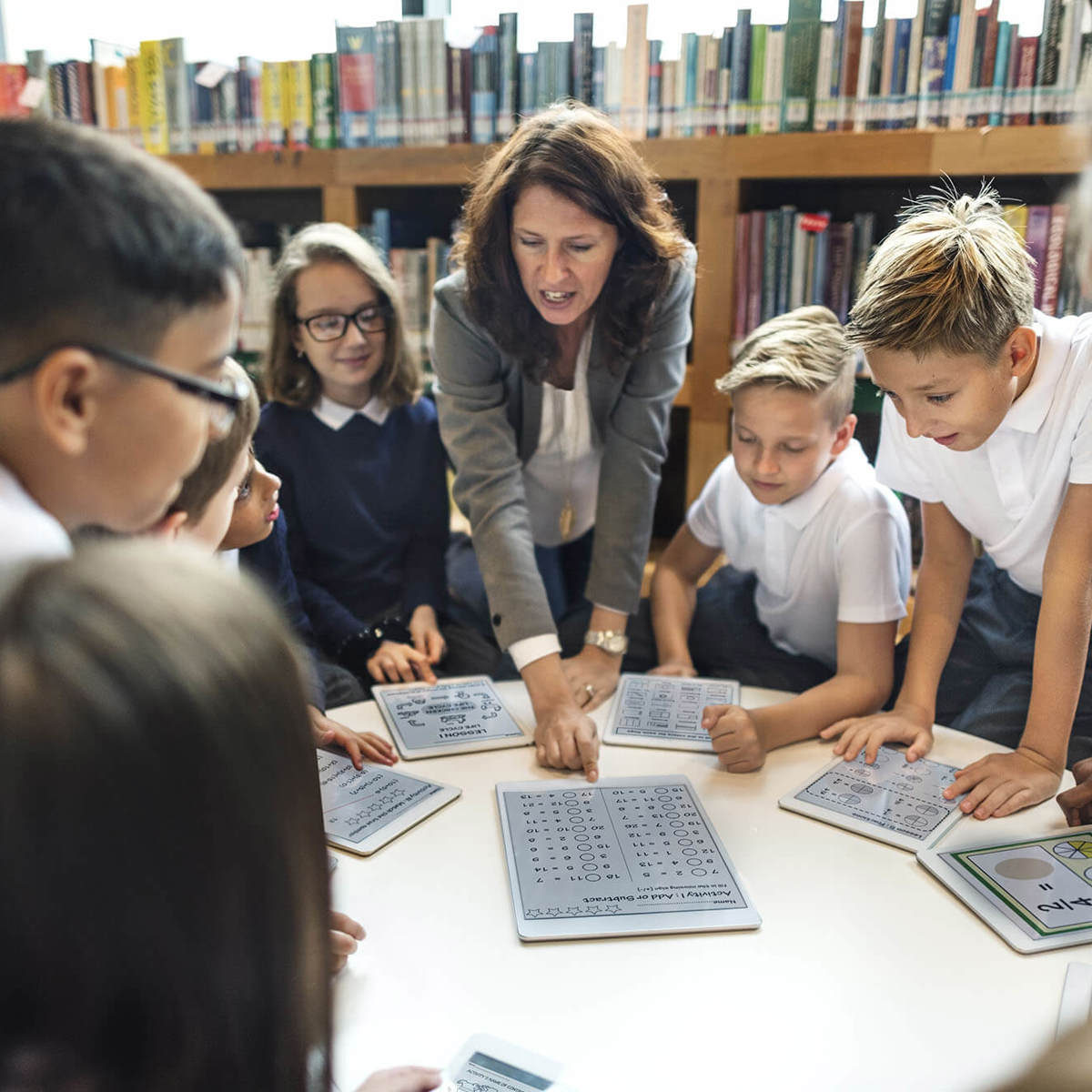 Pupils-learning young pupils around a table of digital tablets learning