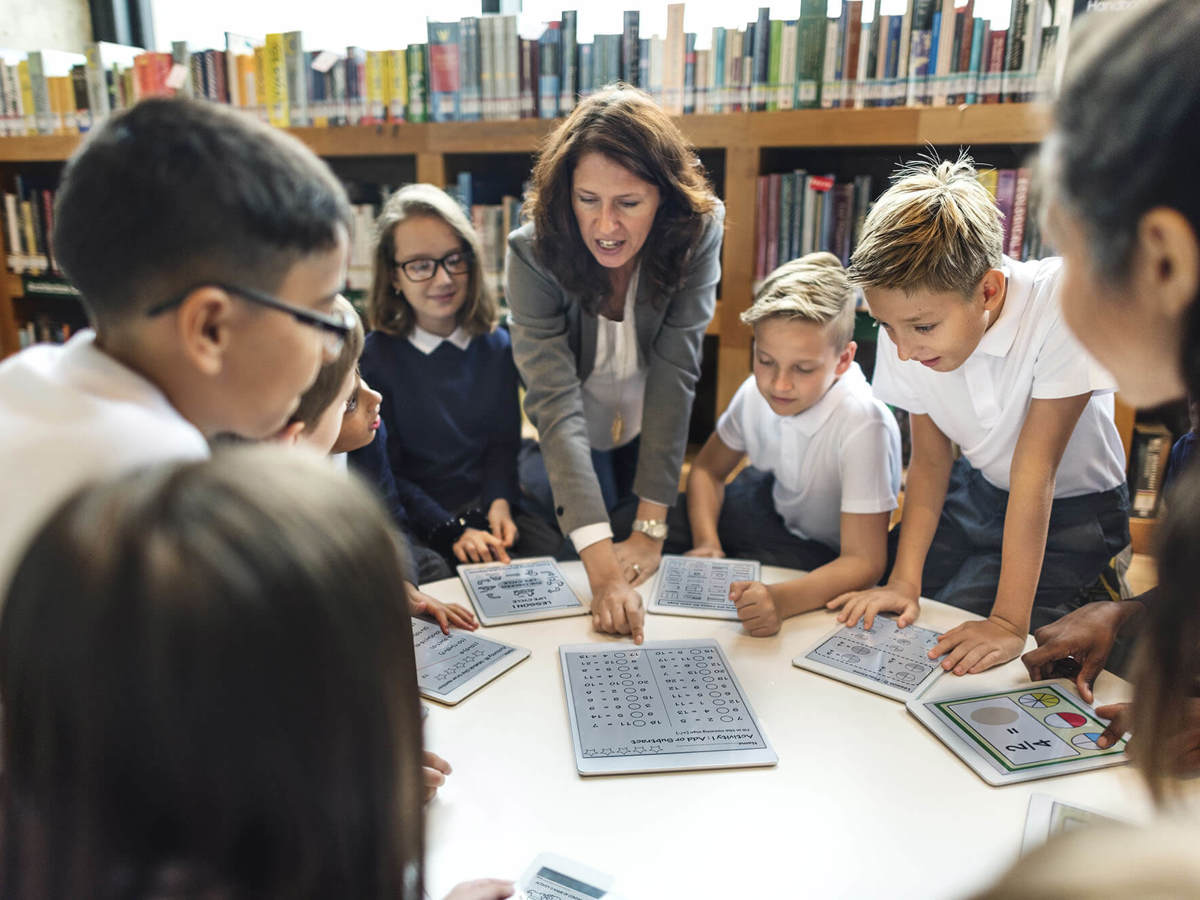 Pupils-learning young pupils around a table of digital tablets learning