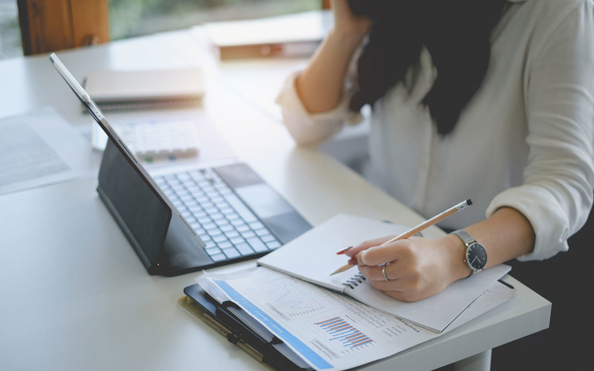 training woman writing notes off laptop