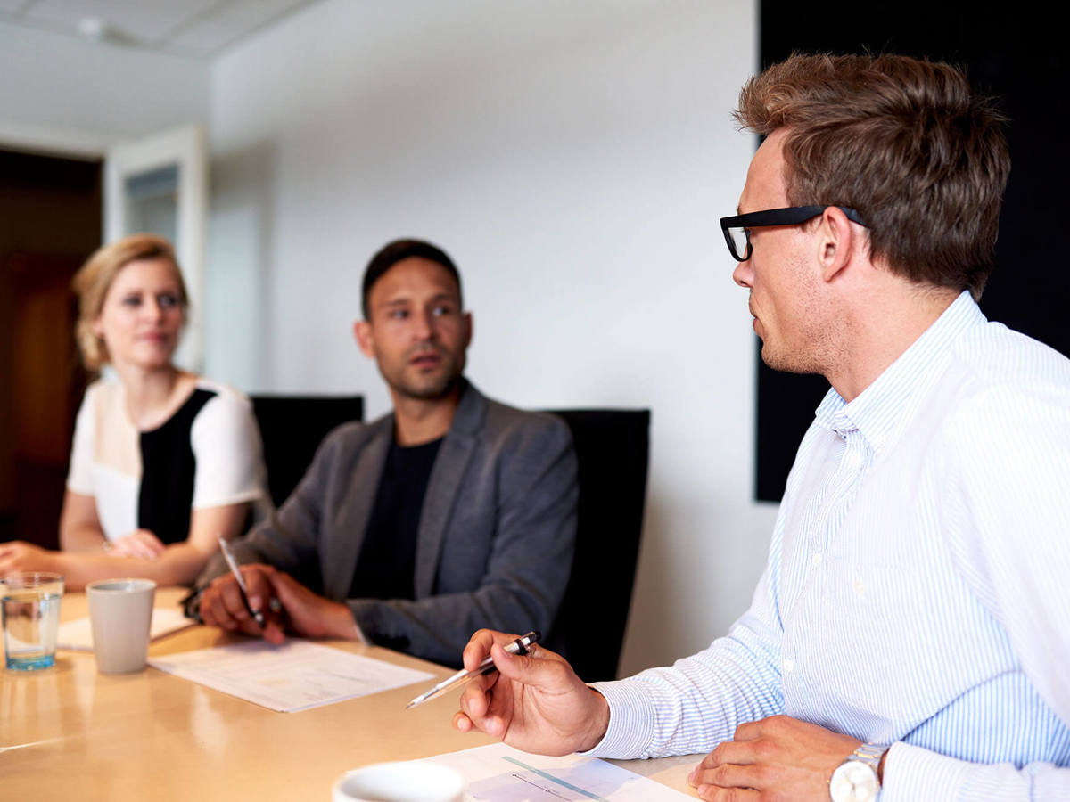 training three people in discussion at table