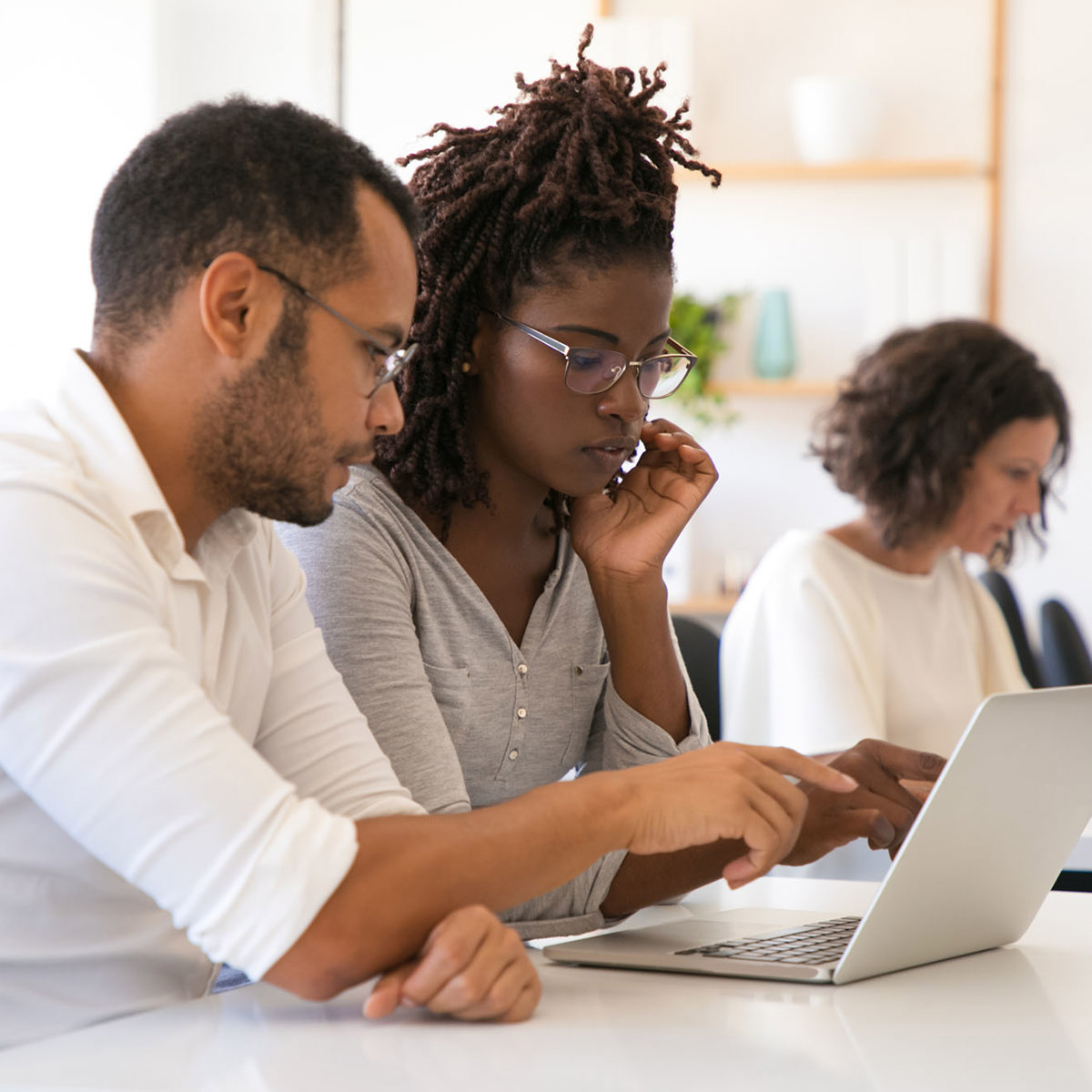 training man and woman working from same laptop