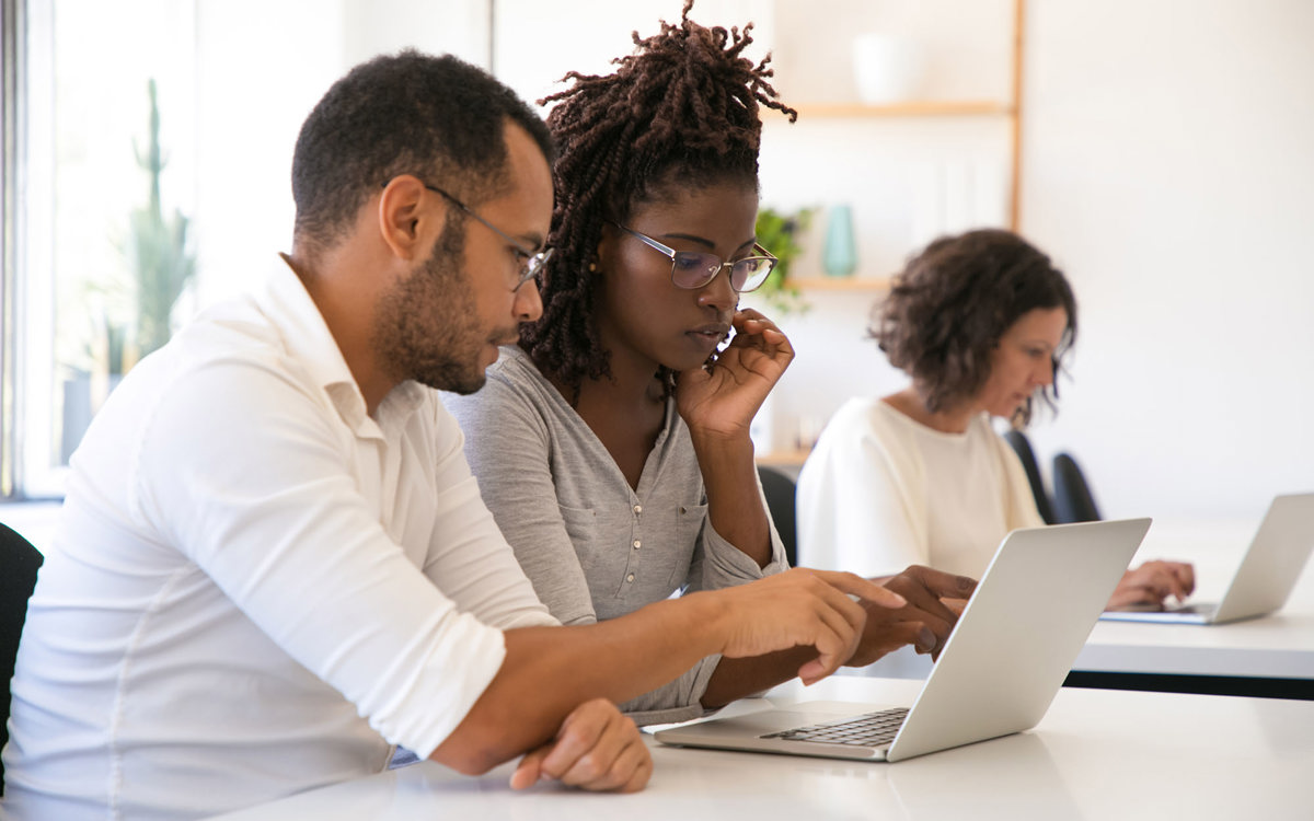 training man and woman working from same laptop