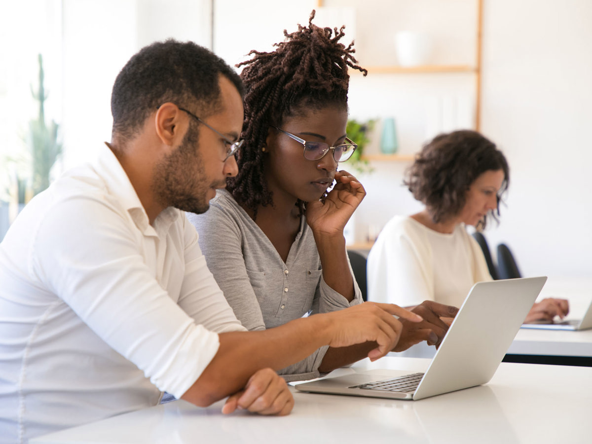 training man and woman working from same laptop