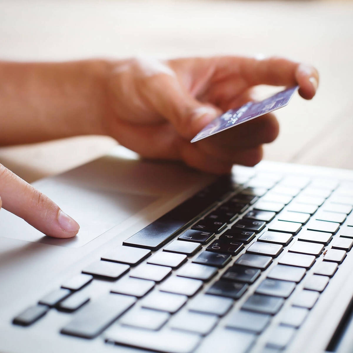 training someone using laptop whilst holding a bank card