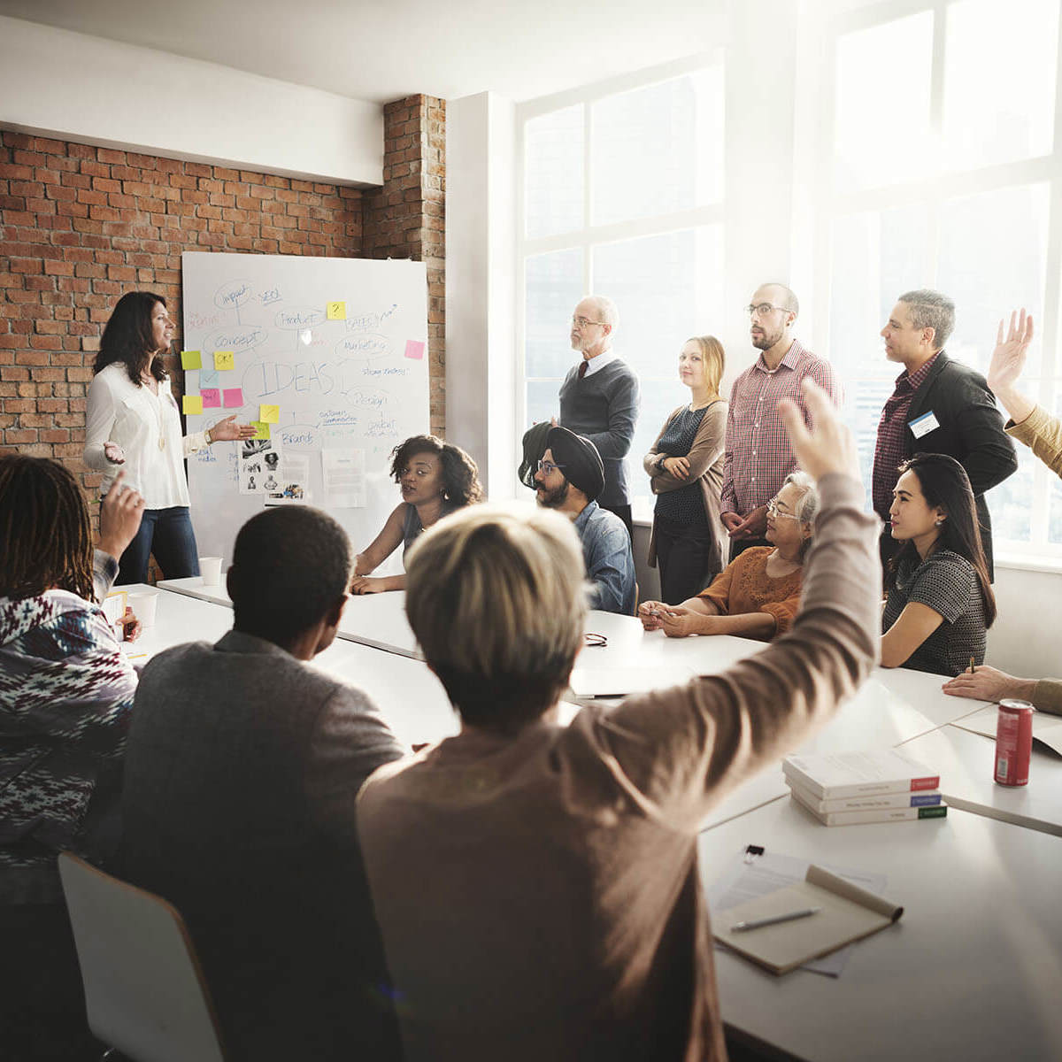 people raising their hands in a meeting room