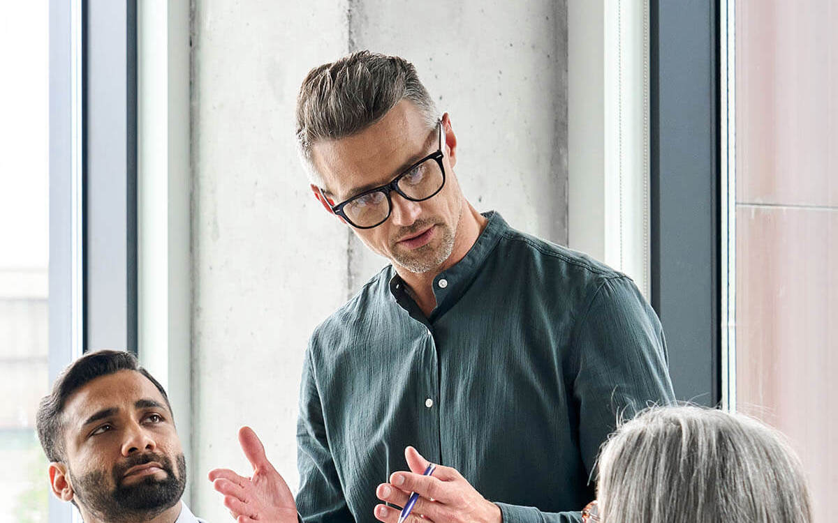 Man talking to two people in meeting
