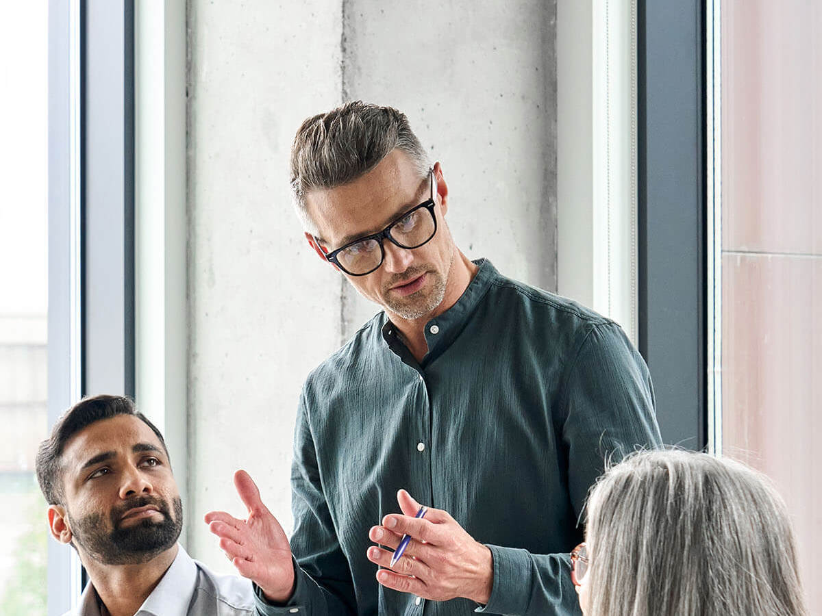 Man talking to two people in meeting