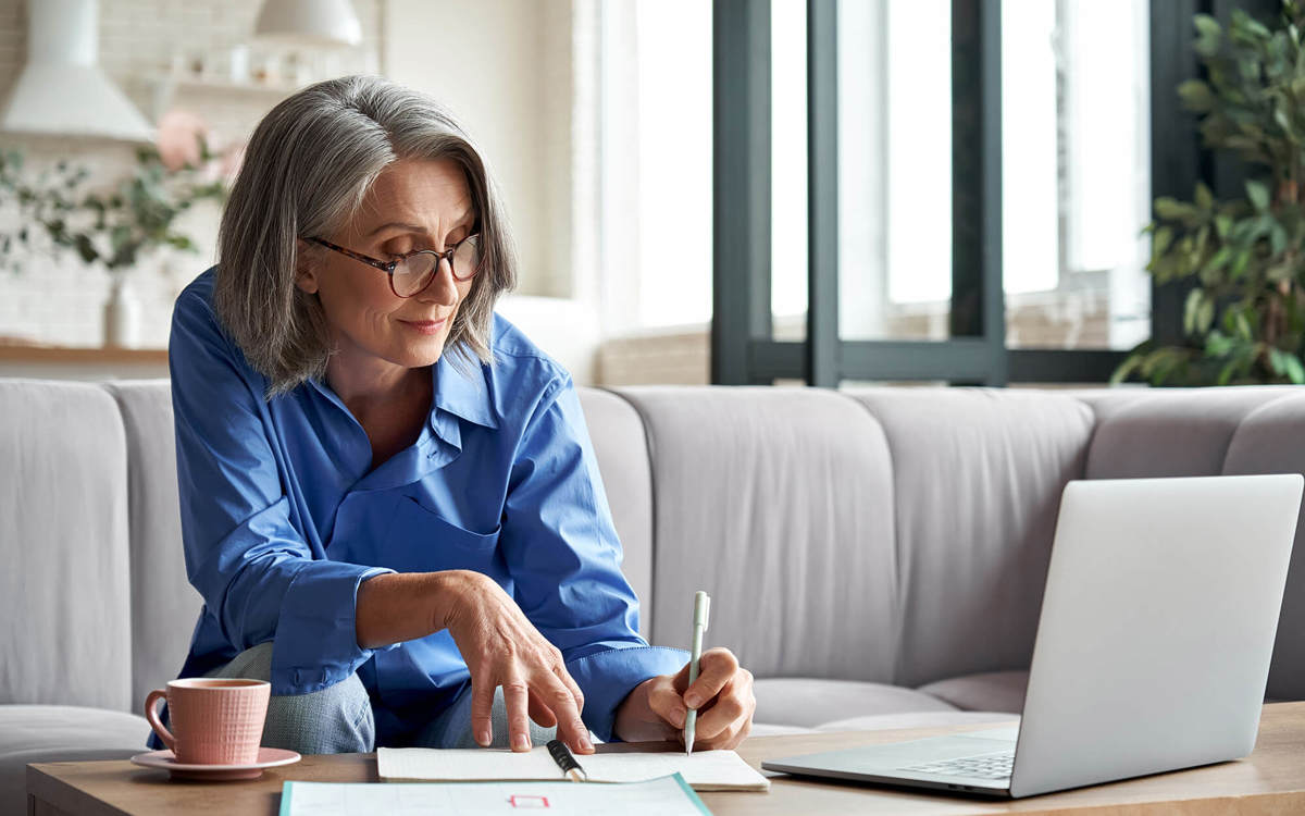 people woman writing notes off her laptop