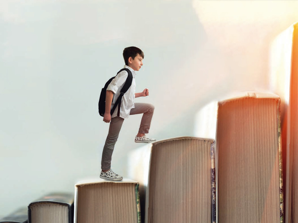 Child climbing stairs made of books