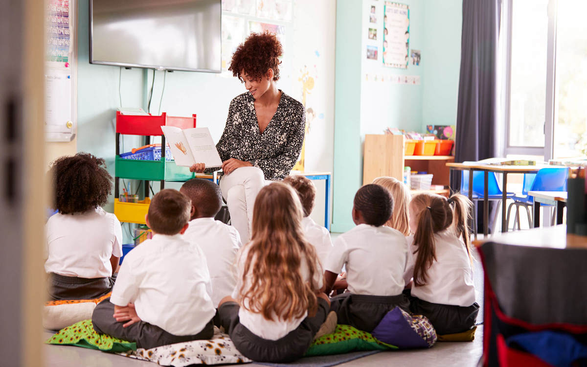 school-environment young pupils in class reading with the teacher