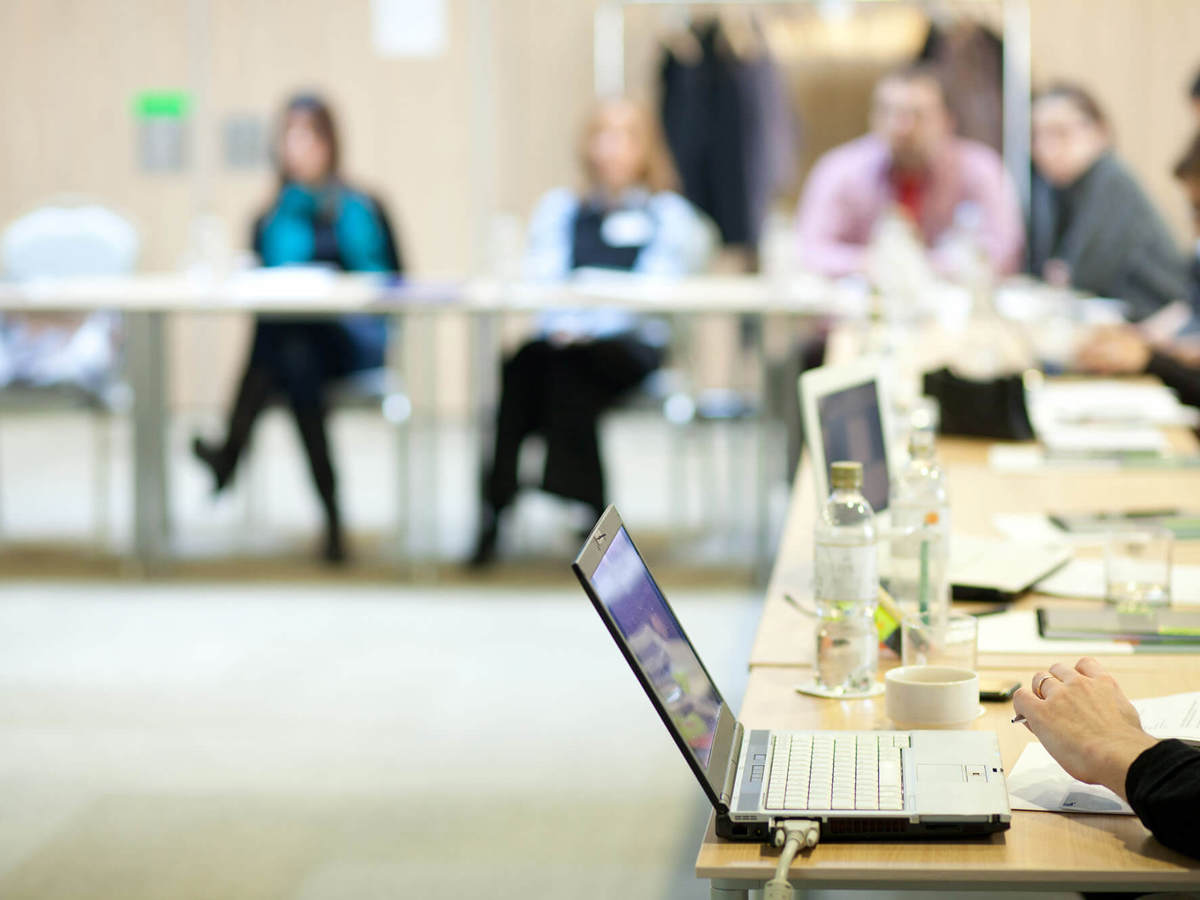training people around table with laptops