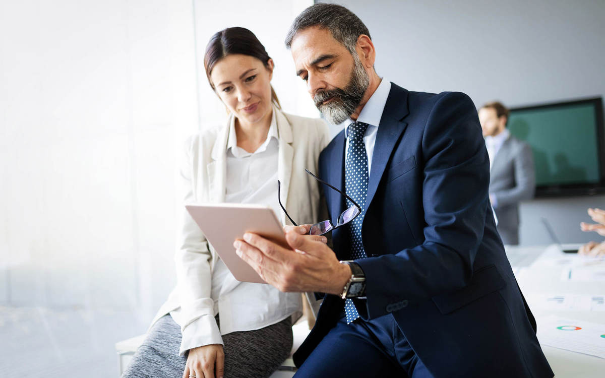 people two people reading off a tablet in a conference room