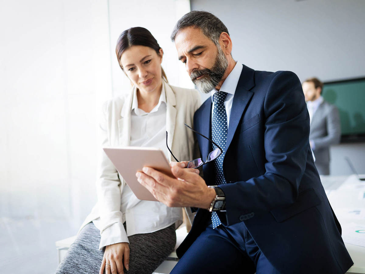 people two people reading off a tablet in a conference room