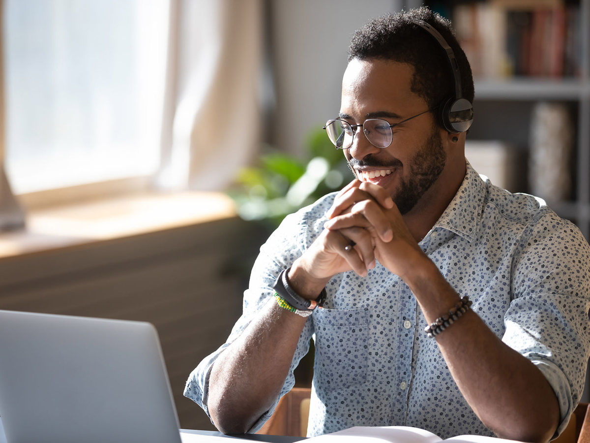 training man smiling at his laptop