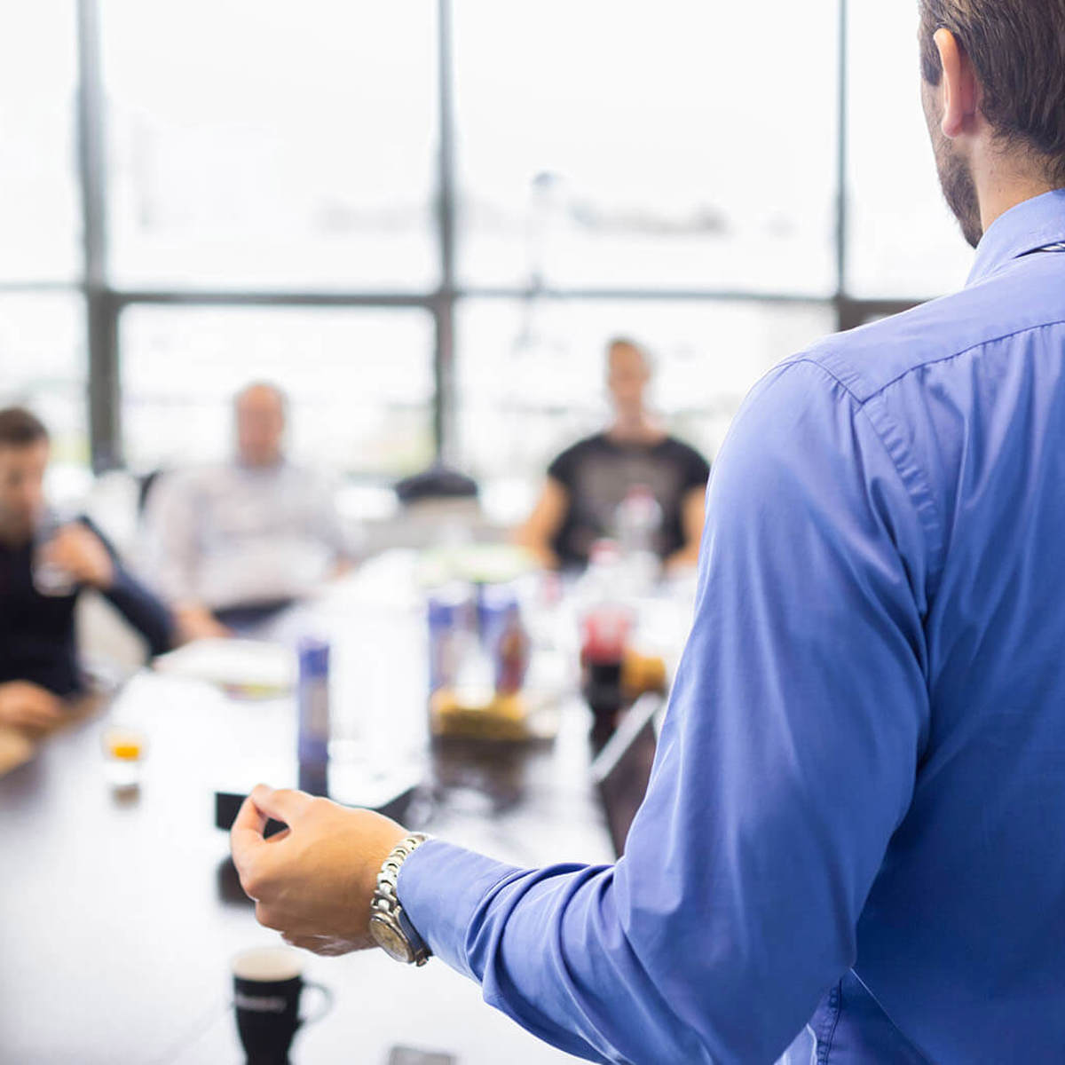 training man presenting to small blurred group