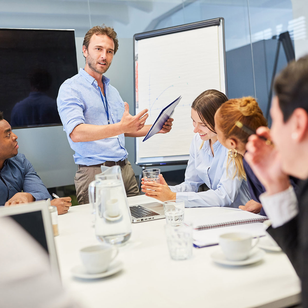 training man presenting to sitting group of people
