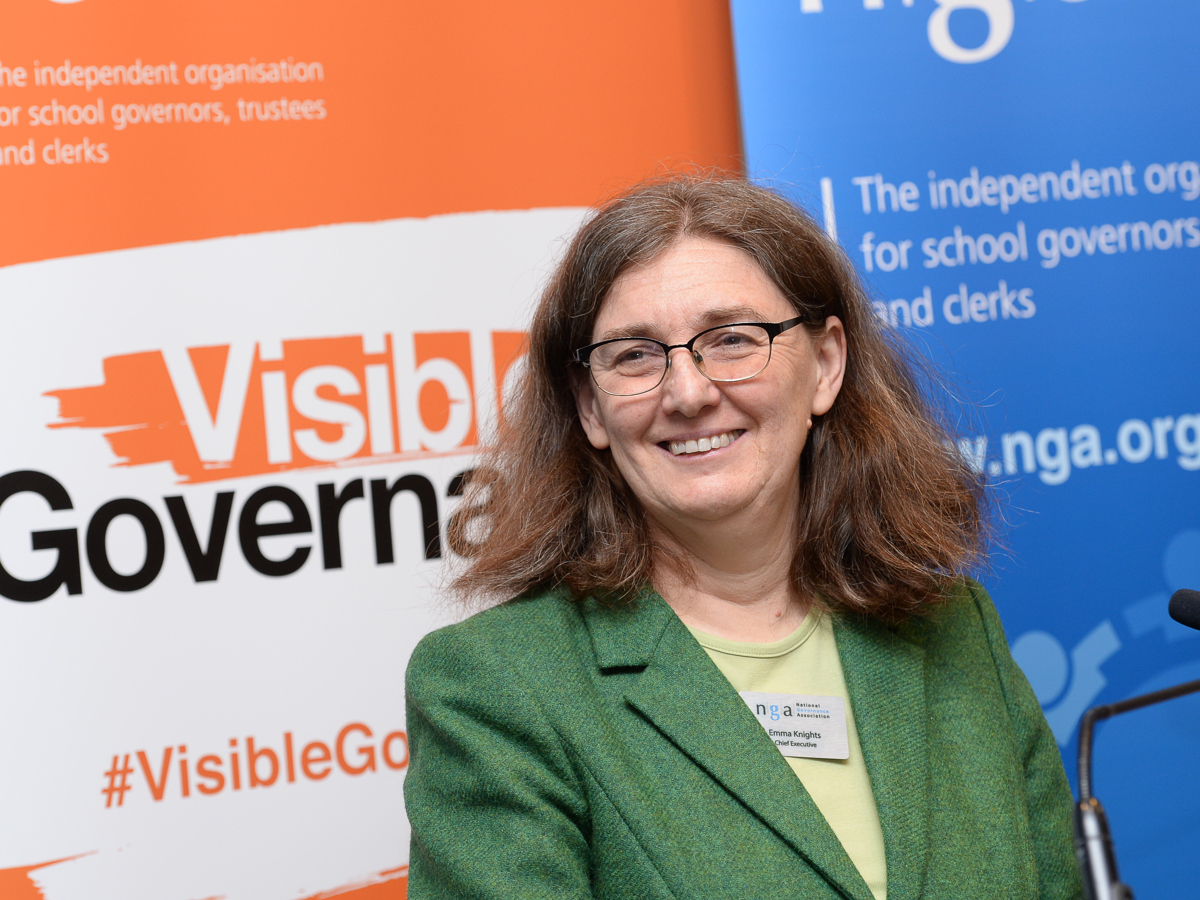 campaigns Emma Knight smiling in front of governance signs