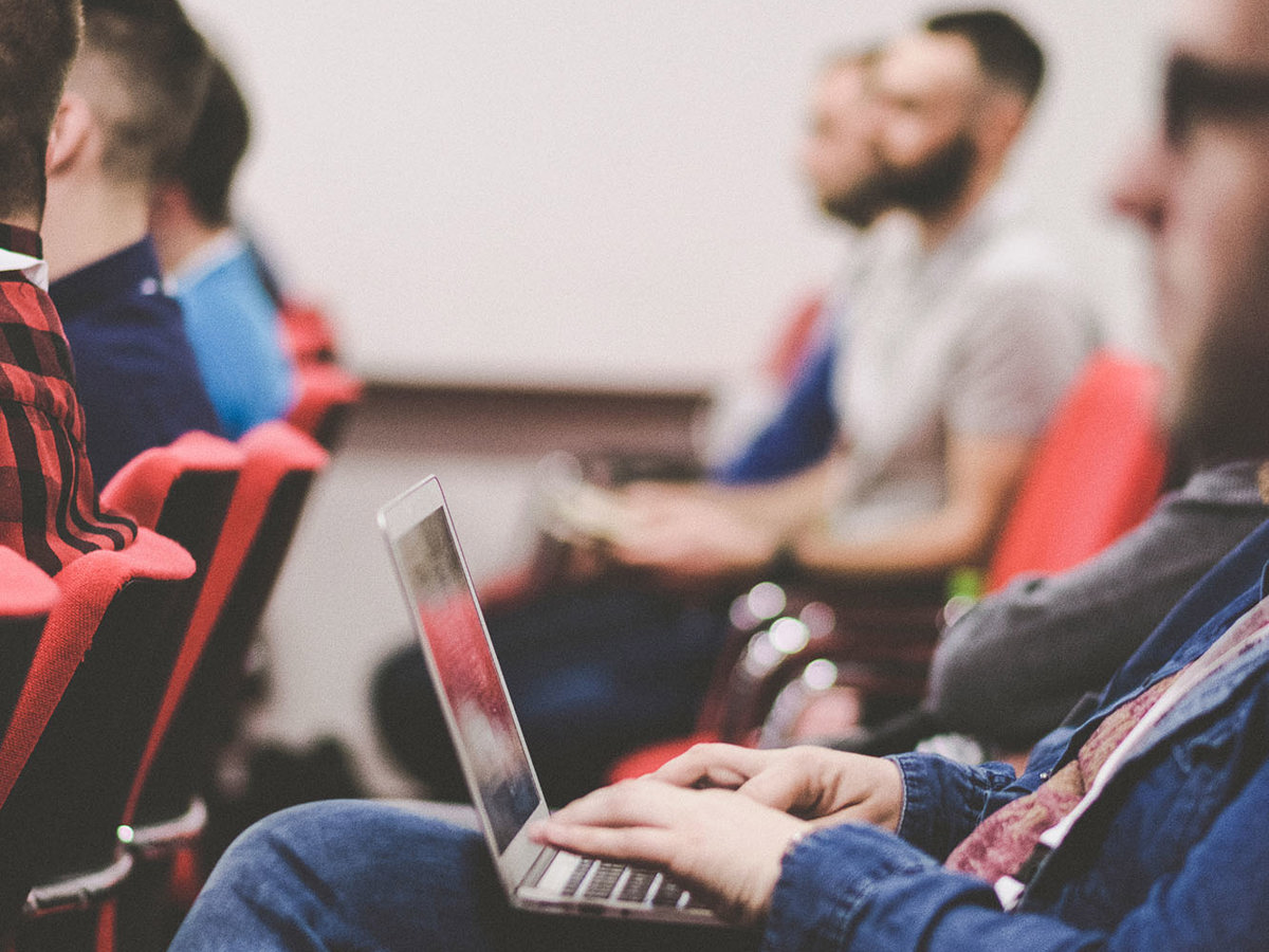 training rows of people in chairs looking same direction blurred