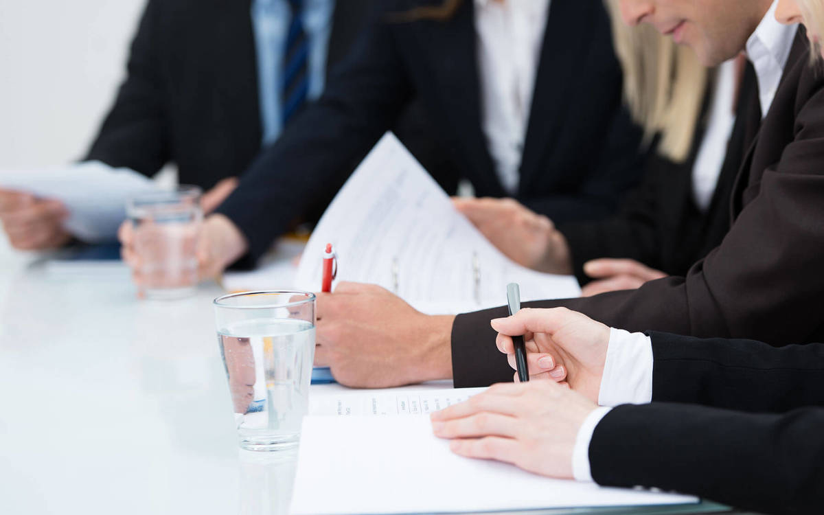 people looking at documents and making notes during a meeting