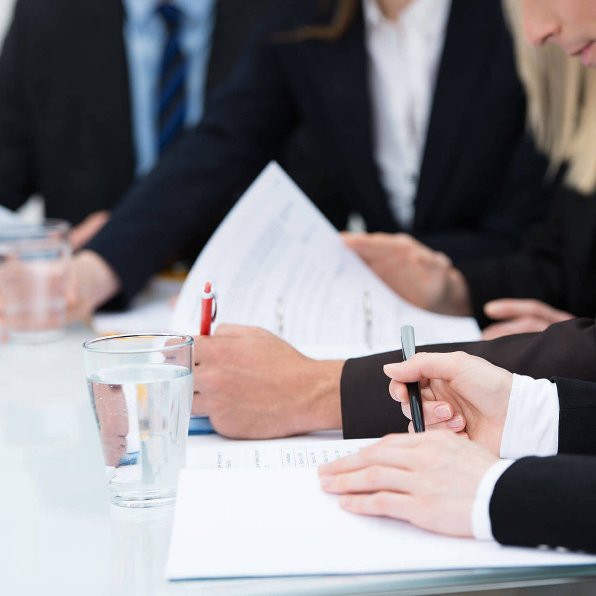 people looking at documents and making notes during a meeting