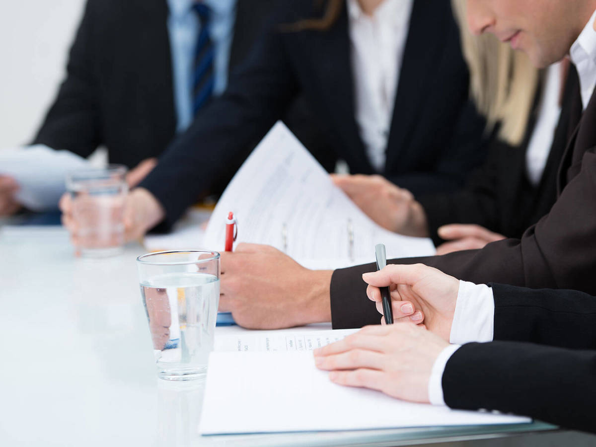 people looking at documents and making notes during a meeting