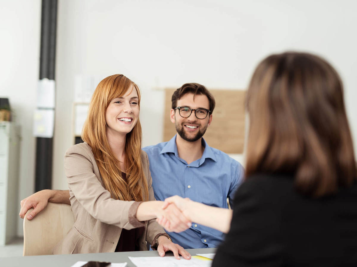 two people shaking hands at a meeting