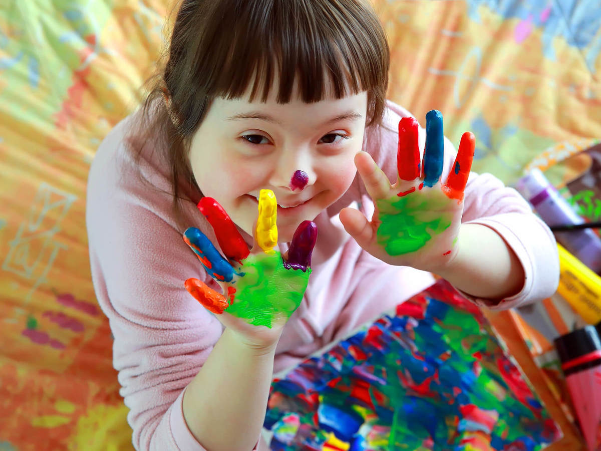 Pupils-learning pupil smiling with paint covered hands