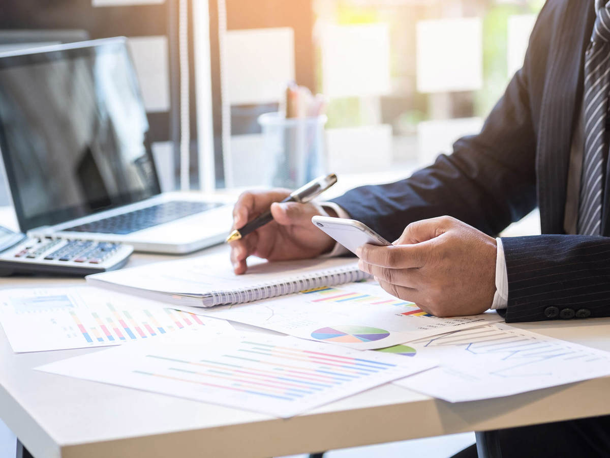 tools-resources man sitting at desk holding phone and pen