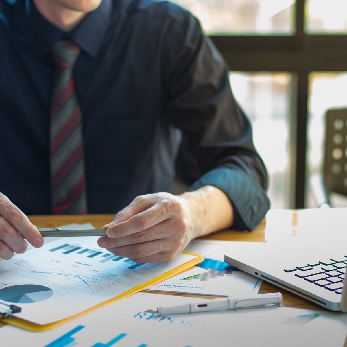 training man with notes watching laptop