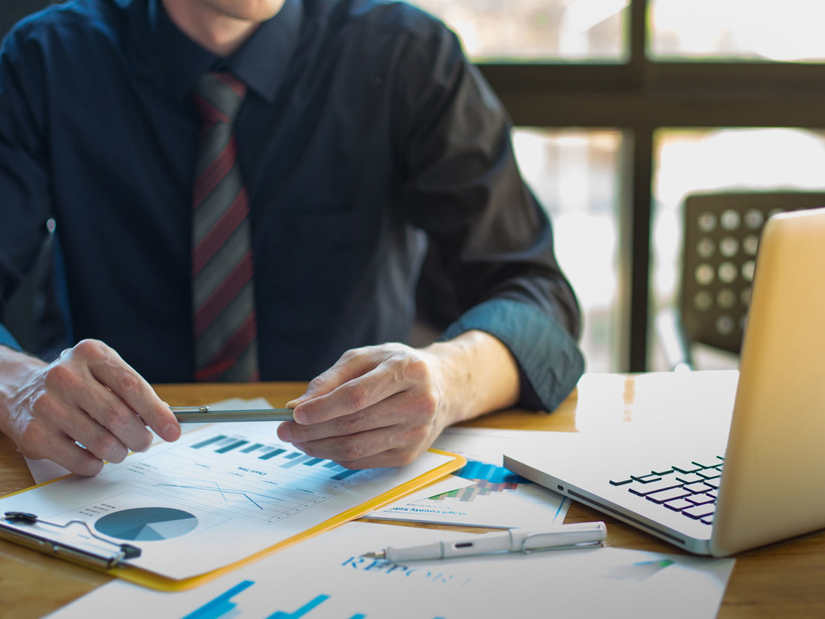 training man with notes watching laptop
