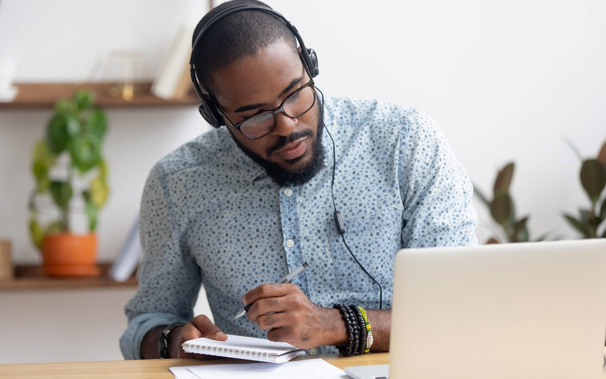 training man writing notes from his laptop