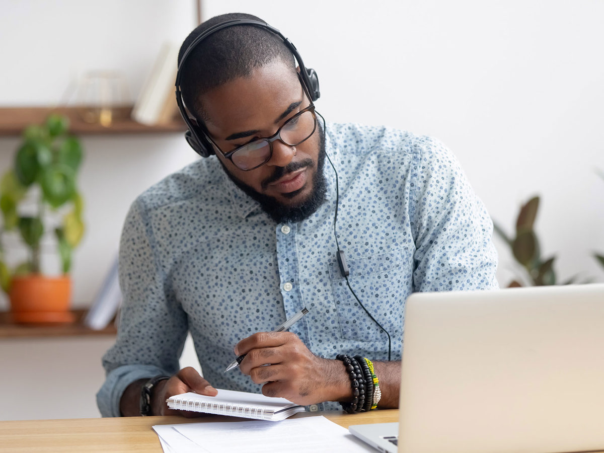 training man writing notes from his laptop