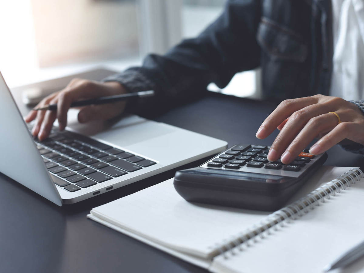 tools-resources someone typing on laptop and putting numbers into a calculator