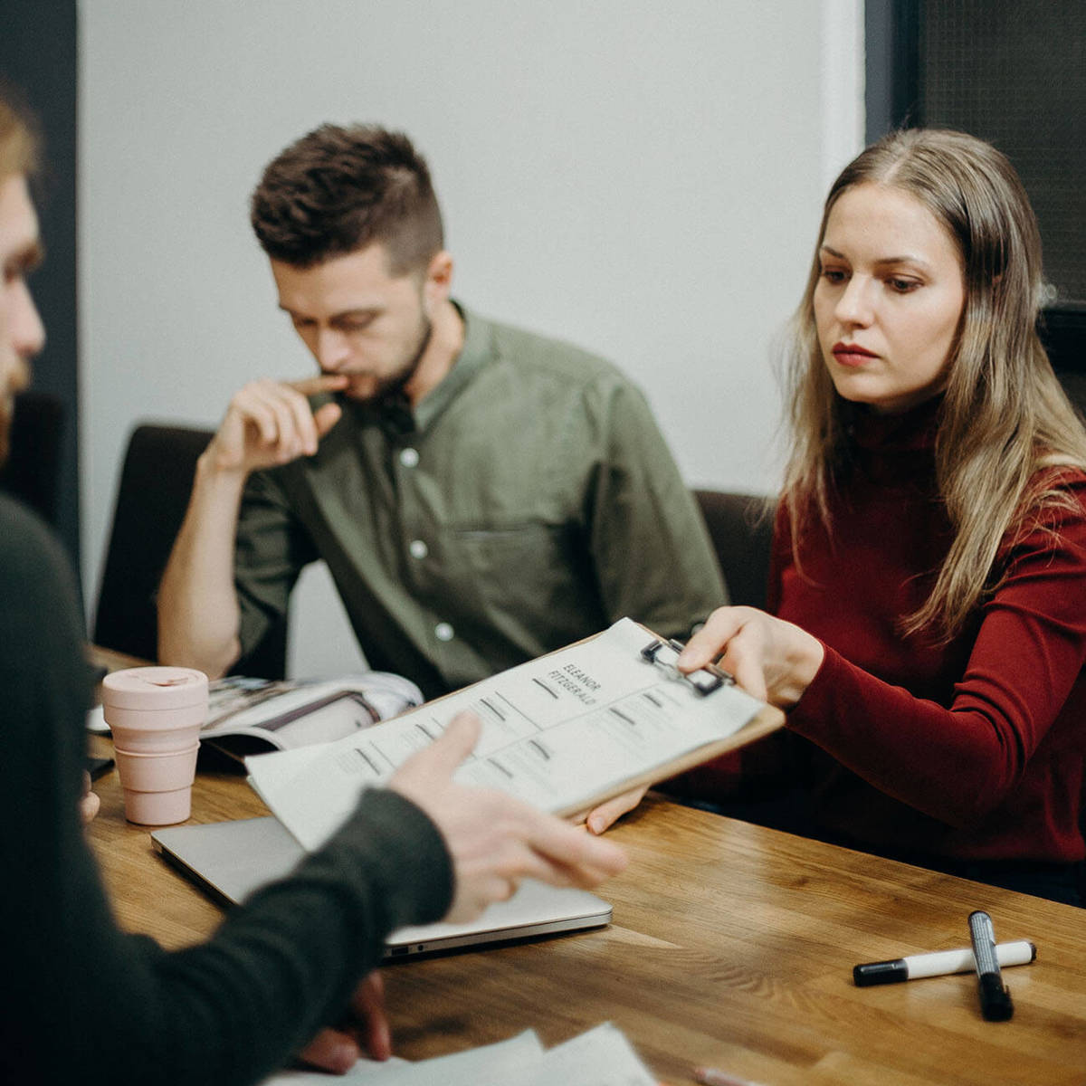 Clipboard being passed to someone else on the table at a meeting