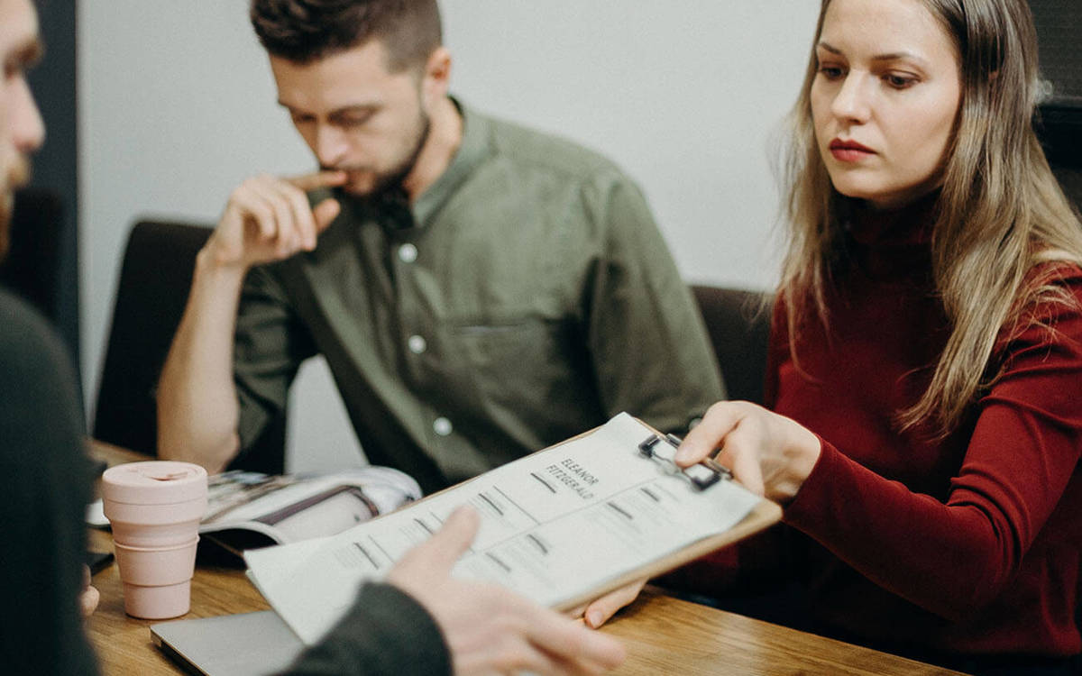 Clipboard being passed to someone else on the table at a meeting