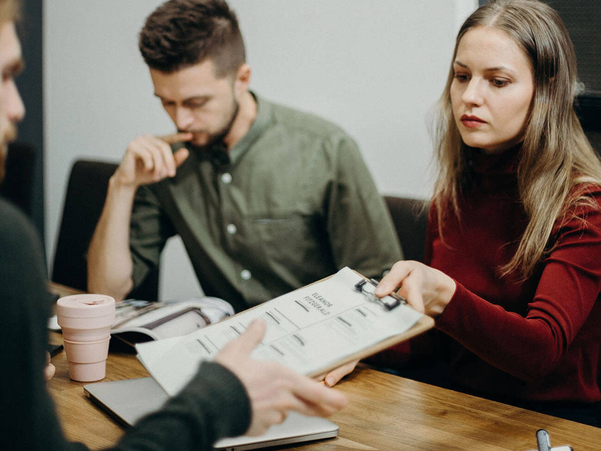 Clipboard being passed to someone else on the table at a meeting