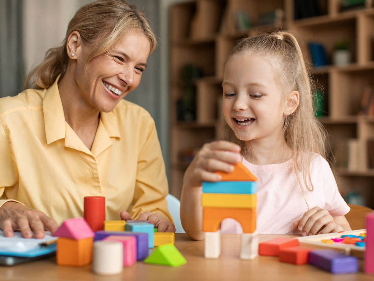 Pupils-learning young pupil happily stacking toy bricks