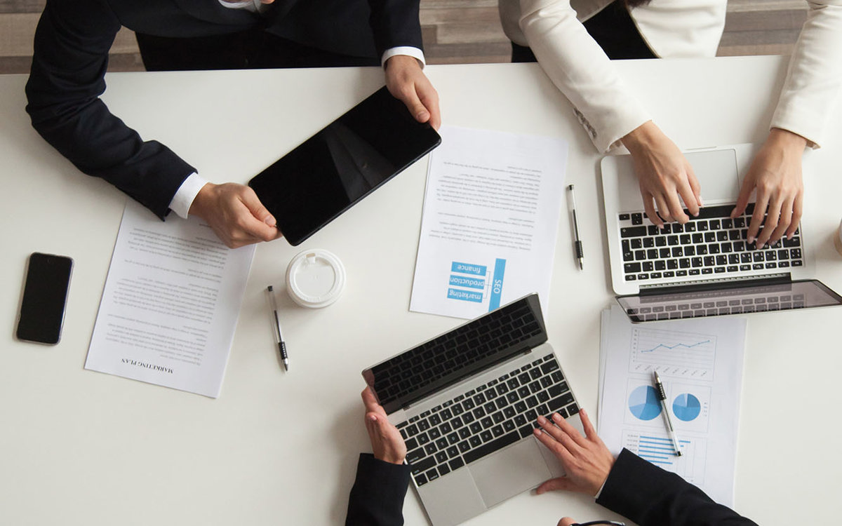 training three people with notes and laptops talking