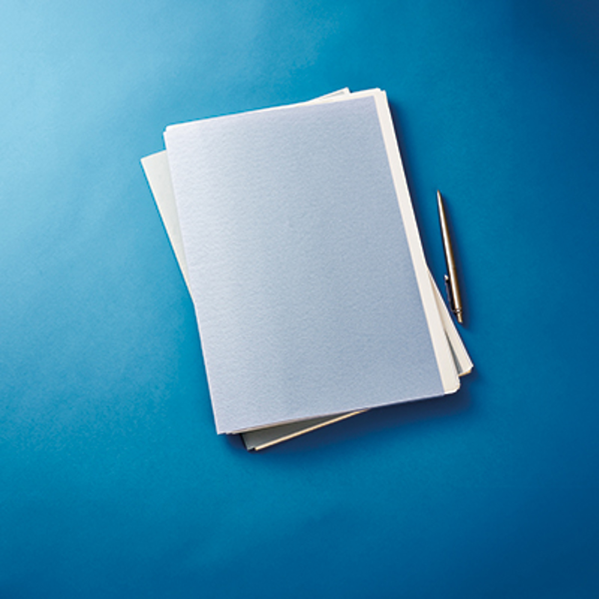 stack of paperwork and pen on blue background