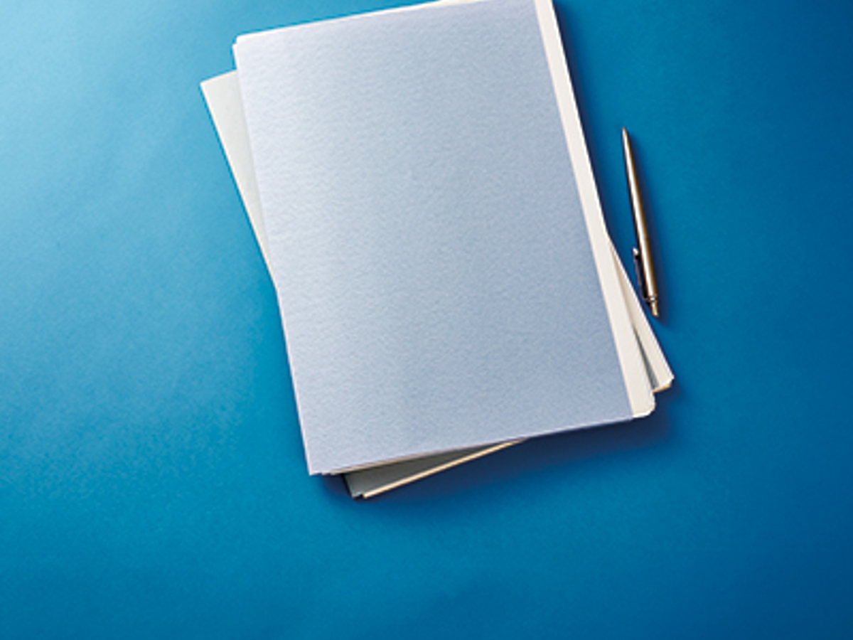 stack of paperwork and pen on blue background