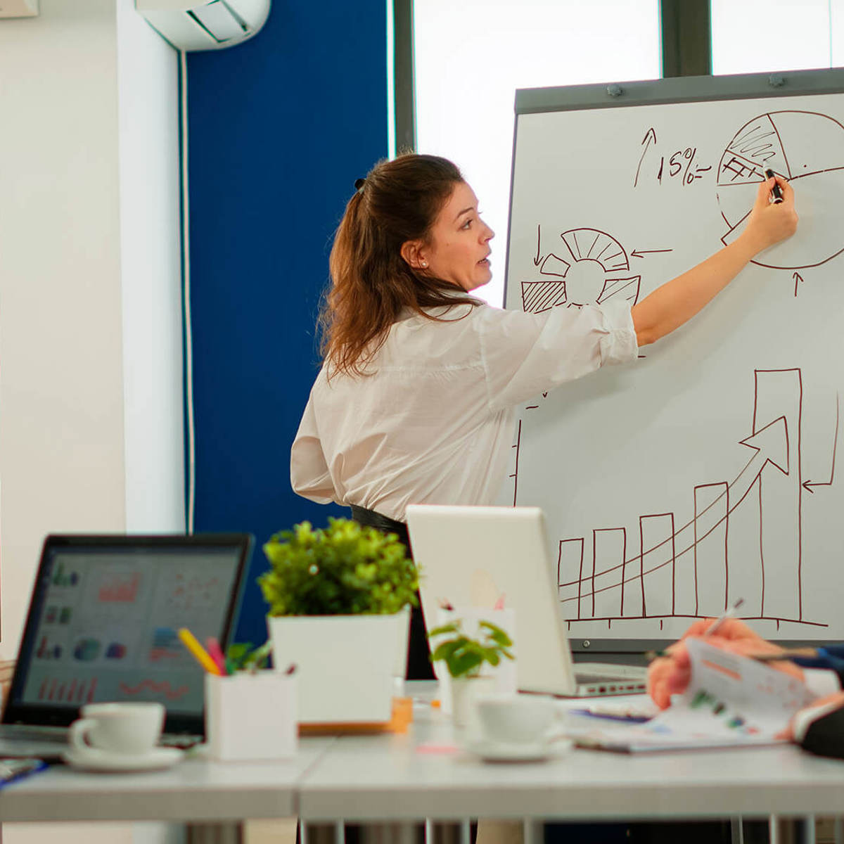 tools-resources woman drawing a graph in front of a small group