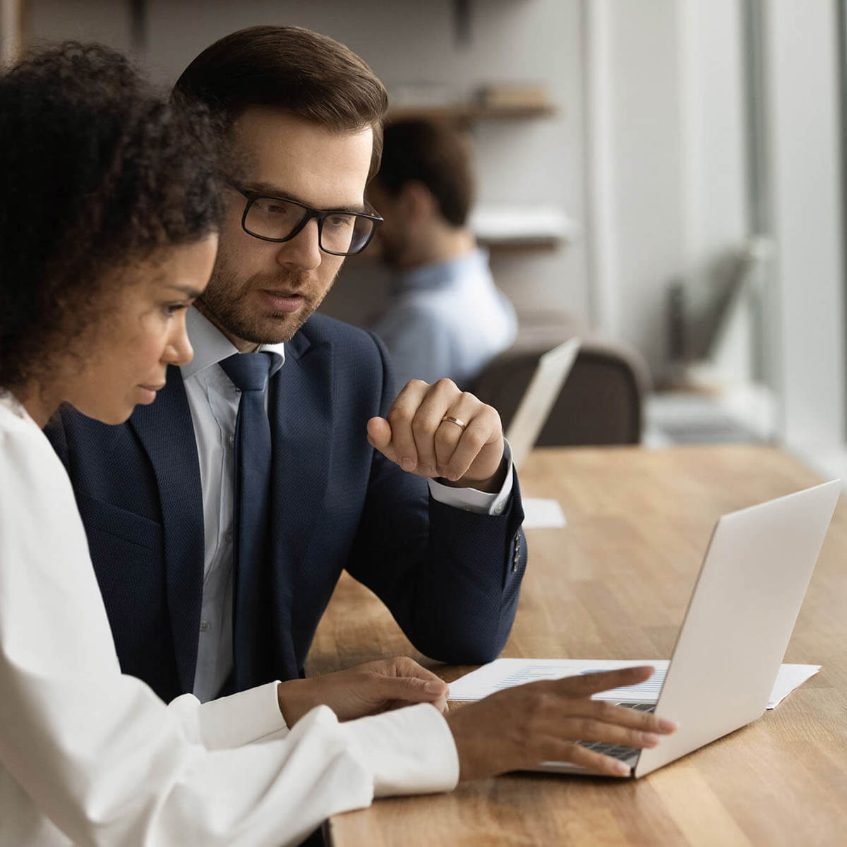 people man and a woman talking in front of their laptop